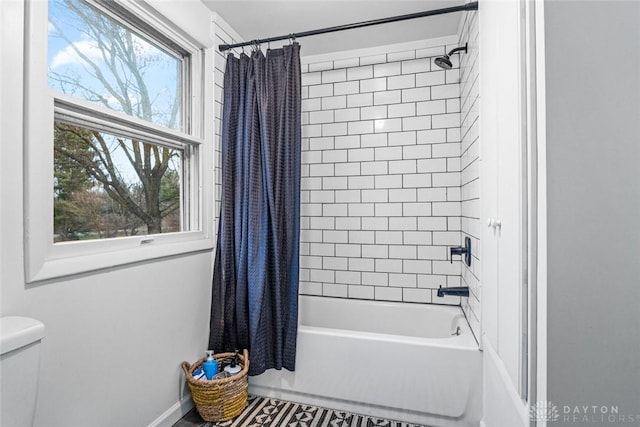 bathroom with shower / bath combo with shower curtain and toilet