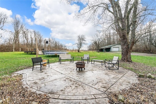 view of home's community featuring an outdoor fire pit, a trampoline, a patio, and a yard