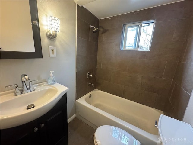 full bathroom featuring tile patterned flooring, vanity, toilet, and tiled shower / bath combo