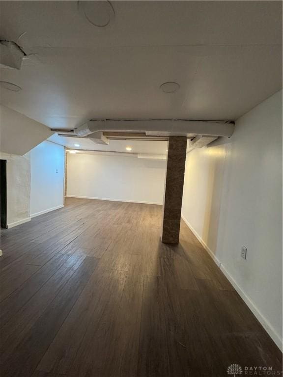 basement with dark hardwood / wood-style floors