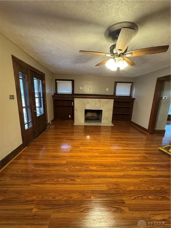 unfurnished living room with ceiling fan, wood-type flooring, and a textured ceiling