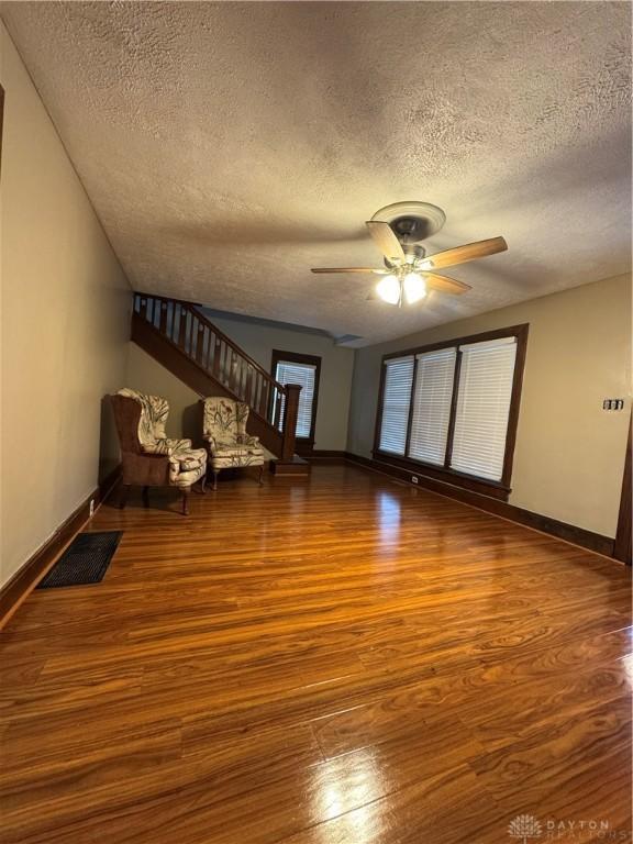 interior space featuring a textured ceiling, hardwood / wood-style flooring, and ceiling fan