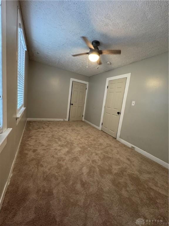 spare room with carpet flooring, ceiling fan, and a textured ceiling