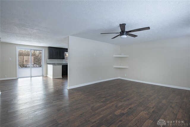 unfurnished living room with dark hardwood / wood-style floors, ceiling fan, and a textured ceiling