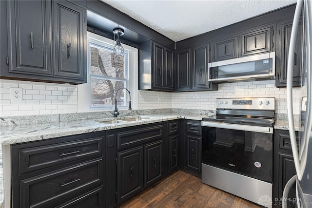 kitchen with sink, light stone counters, a textured ceiling, dark hardwood / wood-style flooring, and stainless steel appliances