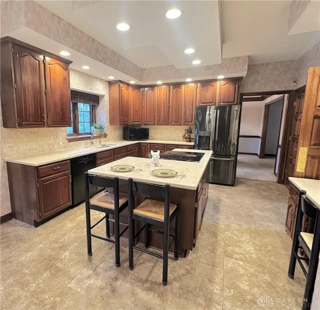 kitchen featuring a kitchen breakfast bar, a kitchen island, and black appliances