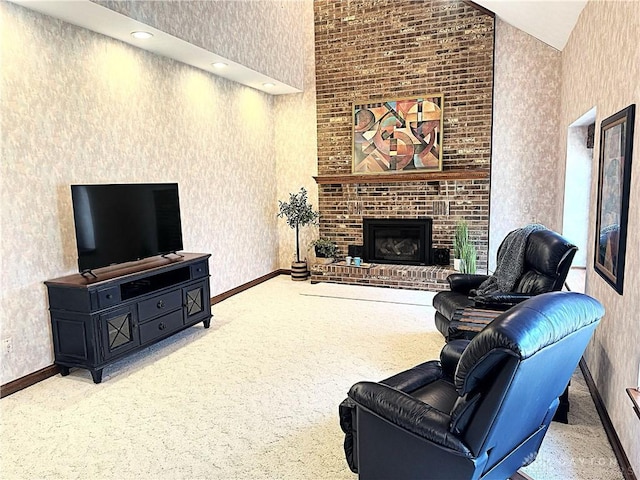 carpeted living room with a fireplace and high vaulted ceiling