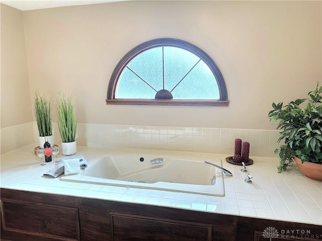 bathroom featuring tiled bath and plenty of natural light