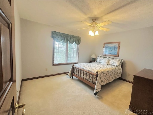 carpeted bedroom featuring ceiling fan and a textured ceiling