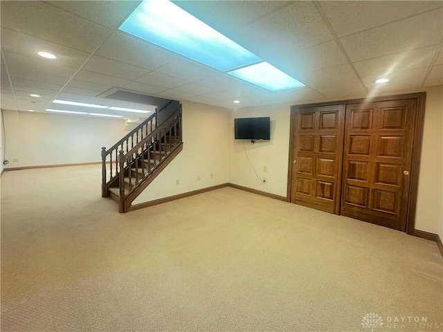 basement featuring carpet and a paneled ceiling