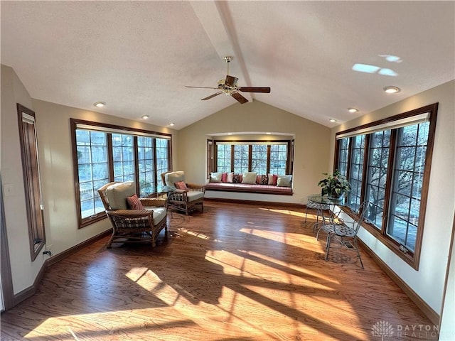 interior space with vaulted ceiling with beams, a healthy amount of sunlight, wood-type flooring, and ceiling fan