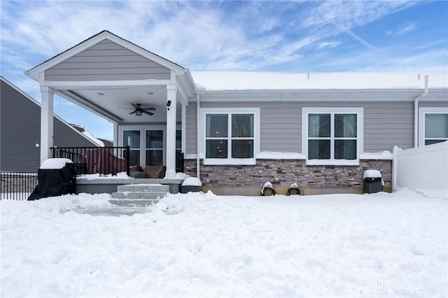 snow covered property featuring ceiling fan