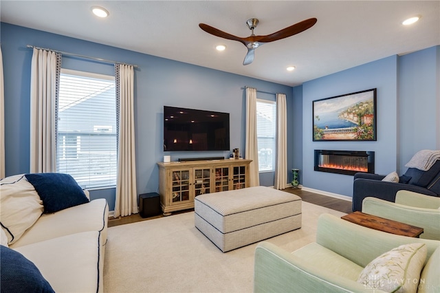 living room with light hardwood / wood-style flooring and ceiling fan