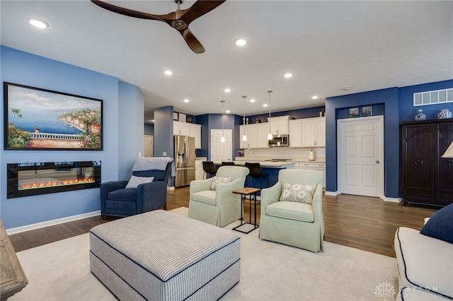 living room featuring ceiling fan and light hardwood / wood-style flooring