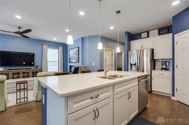 kitchen featuring sink, hanging light fixtures, a center island with sink, white cabinets, and appliances with stainless steel finishes