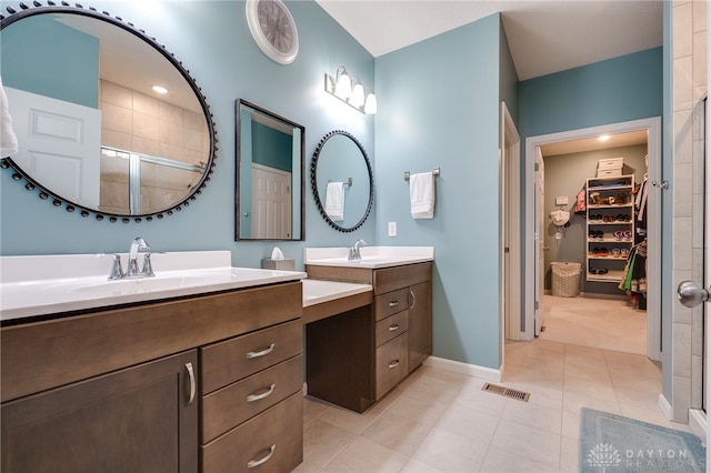 bathroom with tile patterned floors, a shower with door, and vanity