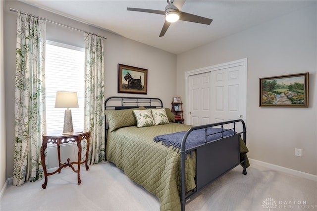 carpeted bedroom featuring ceiling fan and a closet