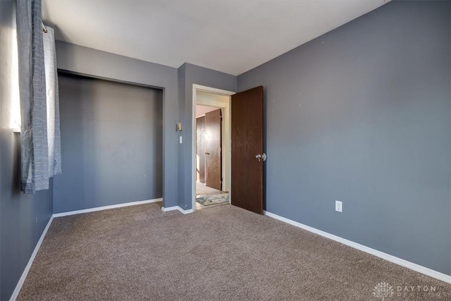 unfurnished bedroom with a closet and carpet