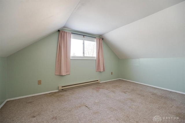 additional living space featuring a baseboard radiator, vaulted ceiling, and carpet