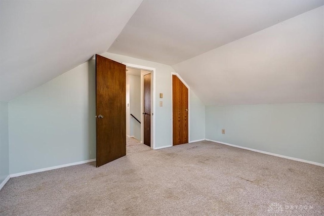 bonus room featuring lofted ceiling and light carpet