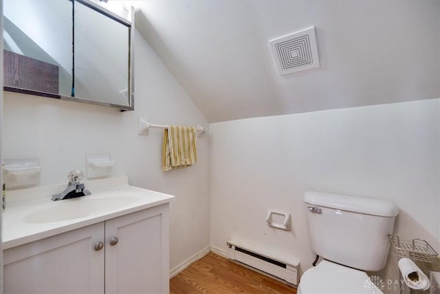 bathroom featuring a baseboard heating unit, vanity, wood-type flooring, vaulted ceiling, and toilet