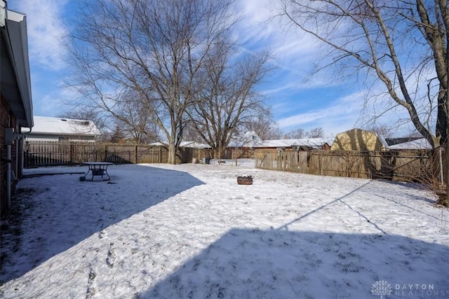 yard layered in snow featuring a fire pit