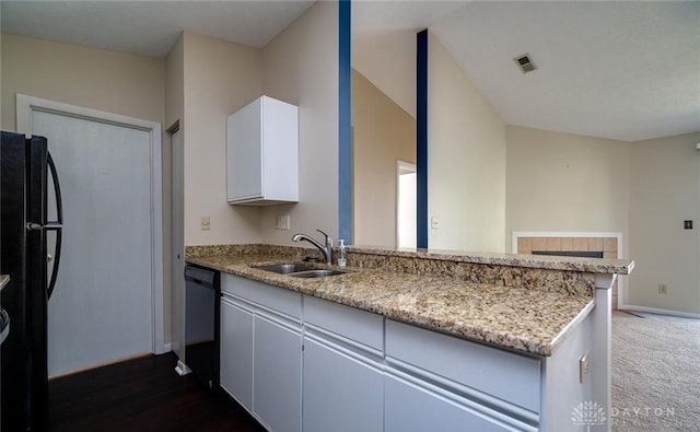 kitchen featuring black appliances, sink, white cabinets, light stone counters, and kitchen peninsula