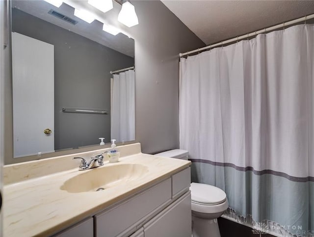 bathroom featuring vanity, a textured ceiling, and toilet