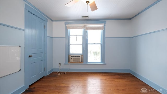 spare room with dark hardwood / wood-style floors, cooling unit, ornamental molding, and ceiling fan