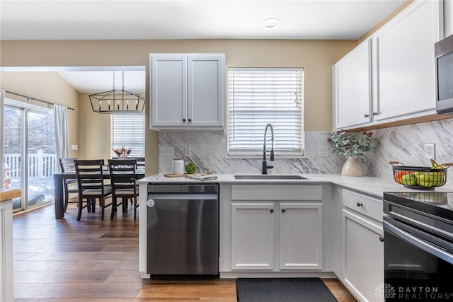 kitchen with white cabinets, decorative backsplash, sink, and stainless steel appliances