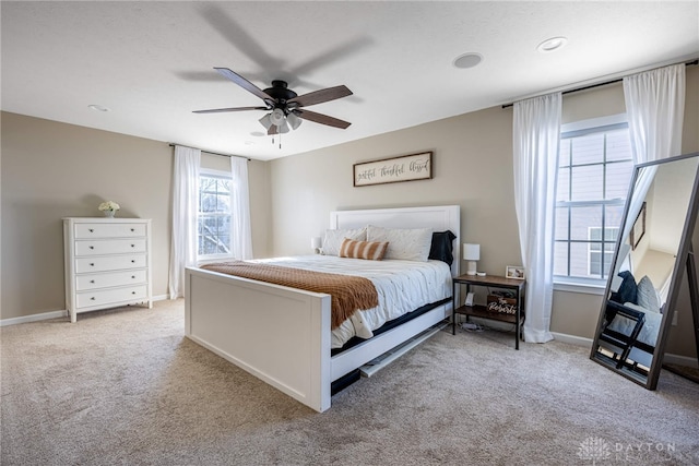 carpeted bedroom with multiple windows and ceiling fan