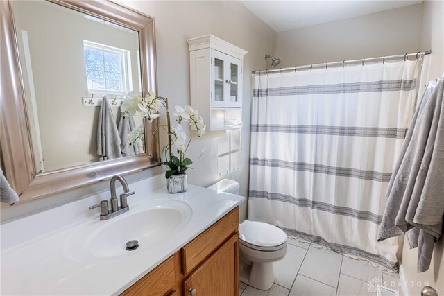 bathroom with tile patterned floors, curtained shower, vanity, and toilet