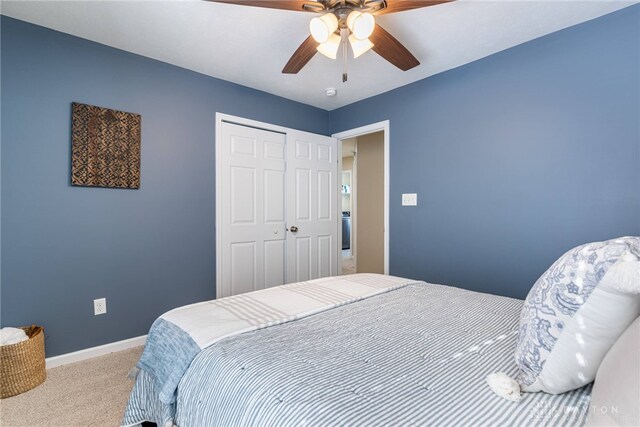 carpeted bedroom featuring ceiling fan and a closet