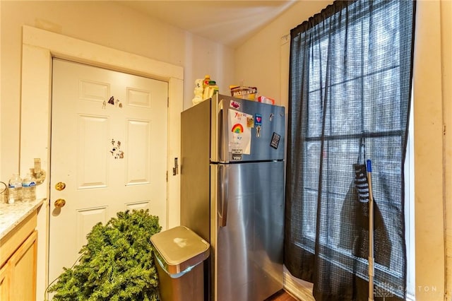 kitchen with light brown cabinets and stainless steel refrigerator