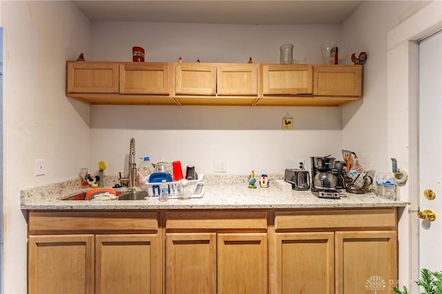 kitchen with light stone counters and sink