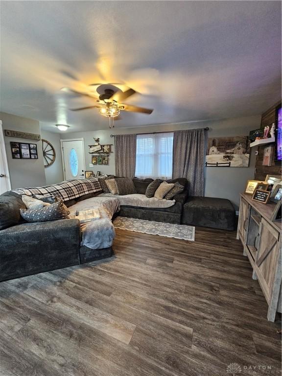 living room with dark hardwood / wood-style floors and ceiling fan