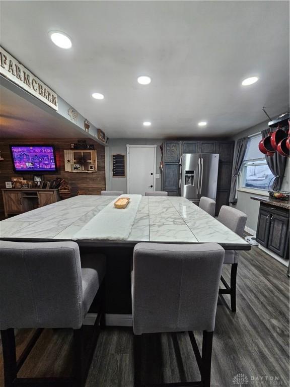 dining area featuring wood walls and dark hardwood / wood-style flooring