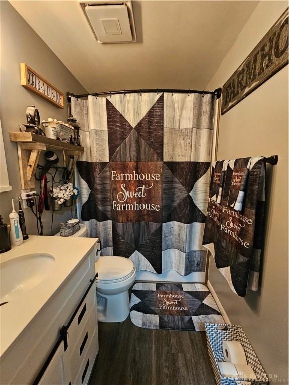 bathroom featuring hardwood / wood-style flooring, vanity, toilet, and a shower with shower curtain