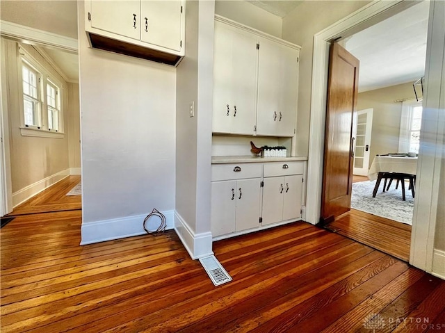 kitchen with dark hardwood / wood-style flooring and white cabinets