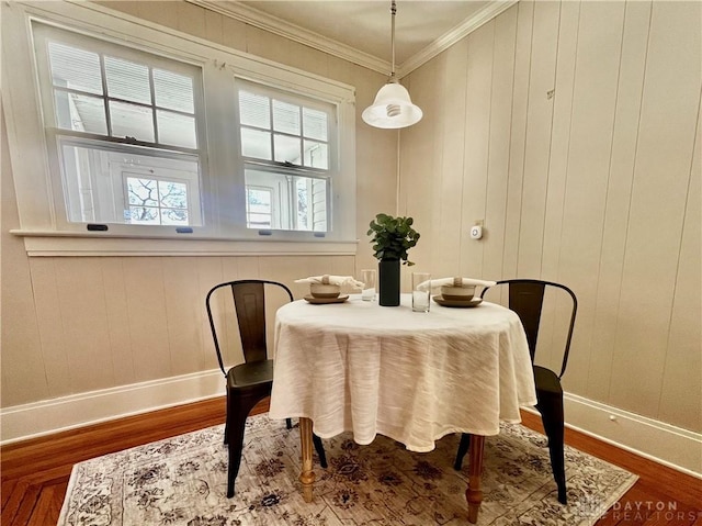 dining area with wood-type flooring and crown molding