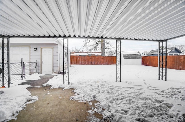 yard layered in snow with an outbuilding