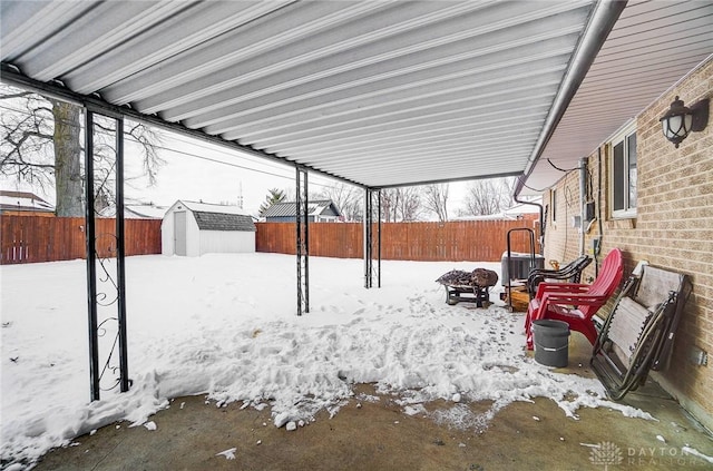 yard layered in snow with a shed and central AC unit