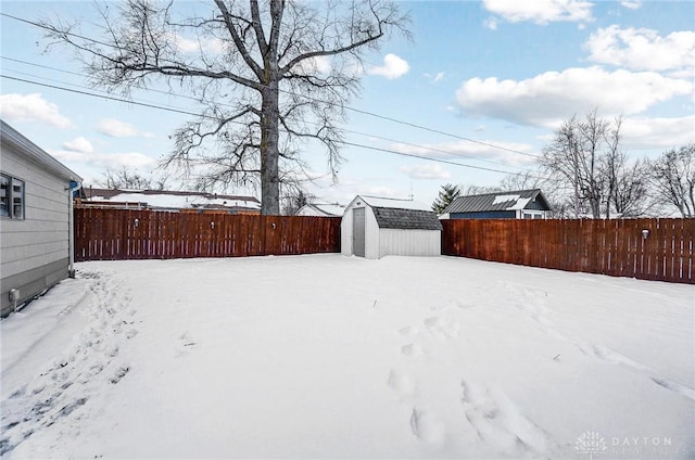 yard covered in snow with a storage unit