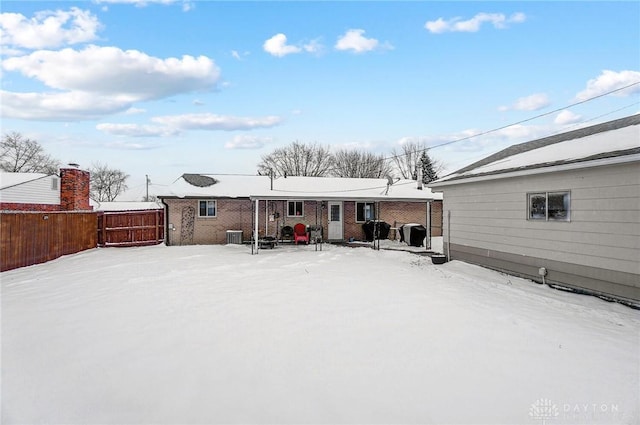 view of snow covered back of property