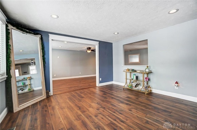 spare room with ceiling fan, dark hardwood / wood-style flooring, and a textured ceiling