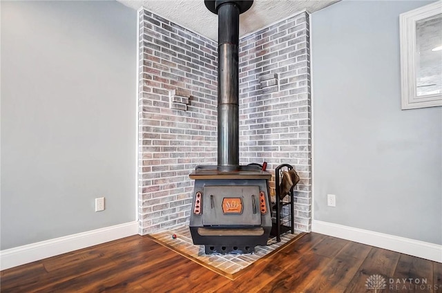 details with a wood stove, hardwood / wood-style floors, and a textured ceiling