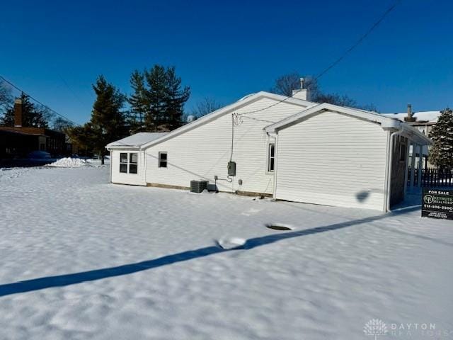 snow covered property featuring central air condition unit