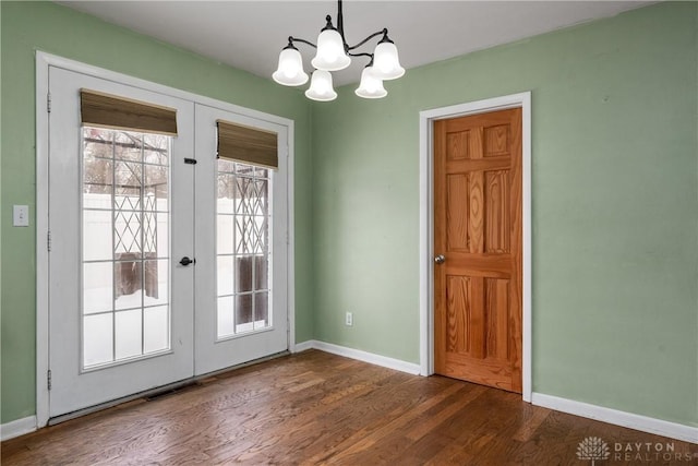 doorway with french doors, dark hardwood / wood-style floors, and a notable chandelier