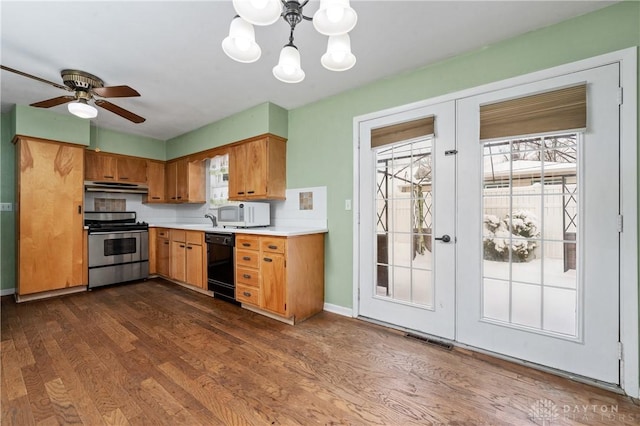 kitchen with dishwasher, backsplash, dark wood-type flooring, ceiling fan with notable chandelier, and stainless steel stove