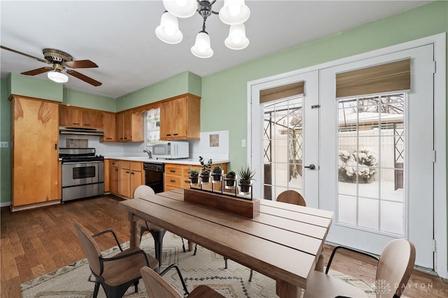 kitchen featuring plenty of natural light, dishwasher, stainless steel stove, and ceiling fan with notable chandelier